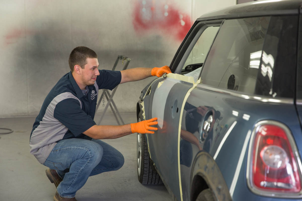 Man taping off car for paint job